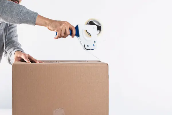 Tape dispenser closing up a box to clear clutter — Vision Realty